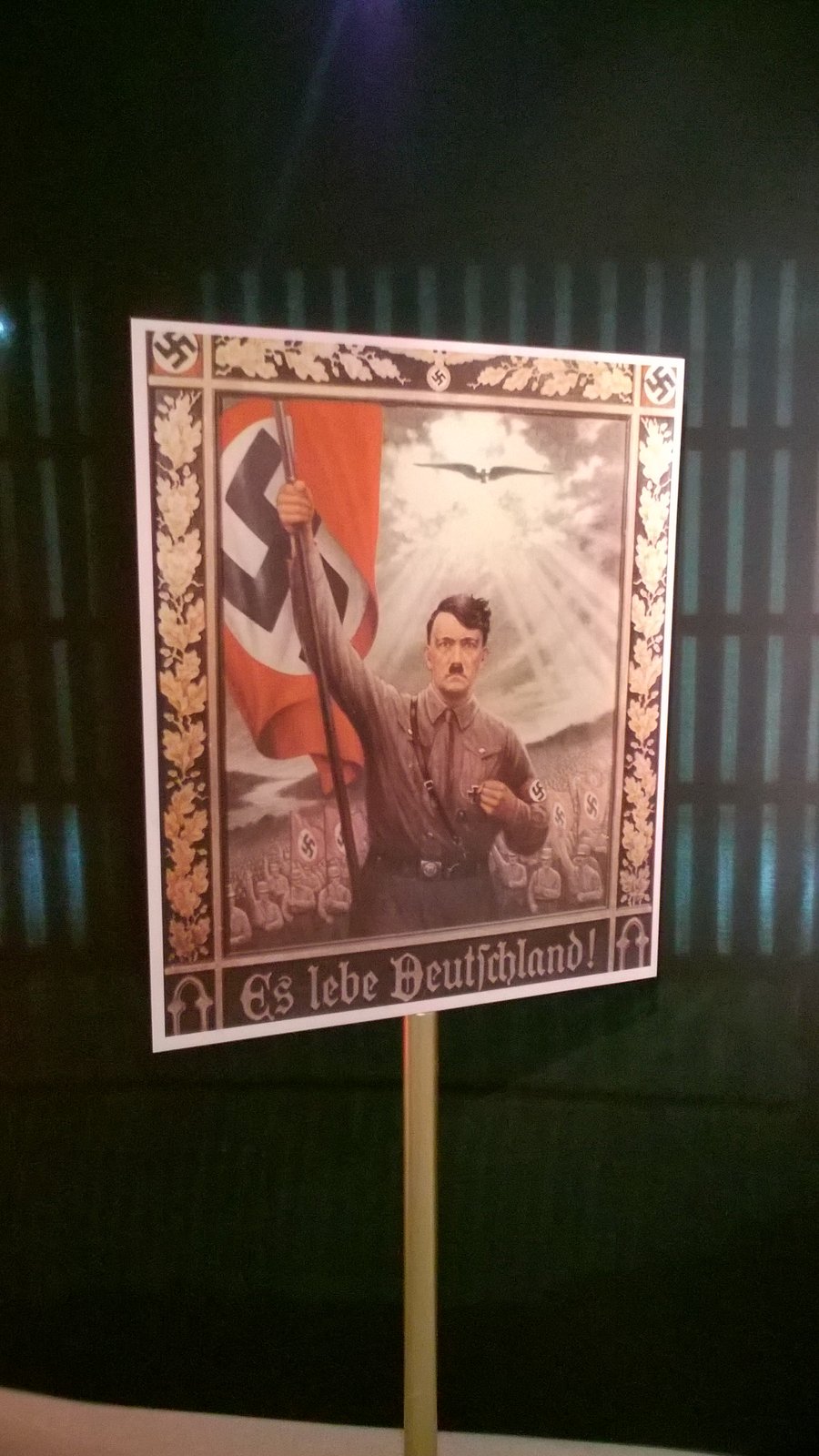 Reprodução de cartaz de propaganda do regime nazista, exibida como material de contextualização histórica na mostra
