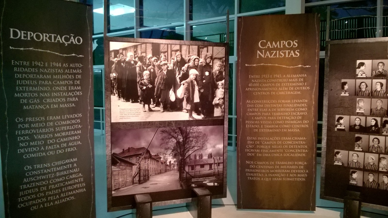 Outro ângulo dos painéis sobre deportação e campos nazistas, com fotos de prisioneiros